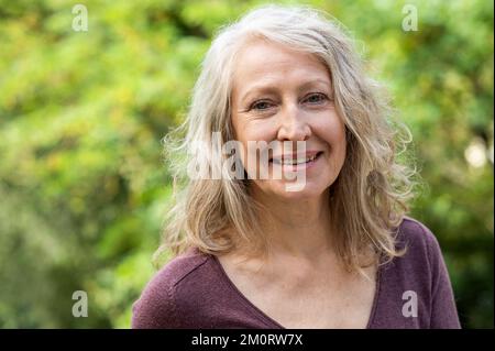 Portrait de dame d'âge moyen regardant la caméra alors qu'elle était assise à l'extérieur dans la cour arrière Banque D'Images