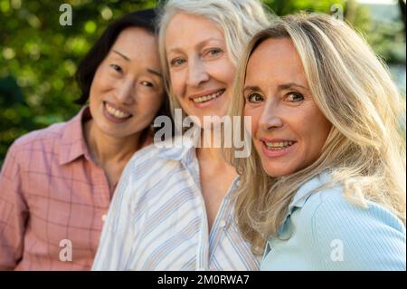 Trois femmes âgées posant ensemble pour une photo de groupe à l'extérieur Banque D'Images