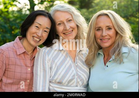 Trois femmes âgées posant ensemble pour une photo de groupe à l'extérieur Banque D'Images