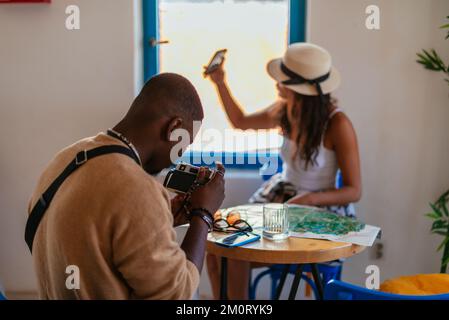 Une belle femme prend un selfie tandis que son petit ami prend une photo avec son appareil photo Banque D'Images