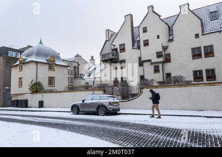 Édimbourg, Écosse, Royaume-Uni, 8th décembre 2022. Météo au Royaume-Uni : neige dans la capitale. Photo : la neige tombe sur la rue pavée de Leith à Lamb's House avec un homme qui marche de l'autre côté de la route vide en regardant son téléphone. Crédit : Sally Anderson/Alay Live News Banque D'Images