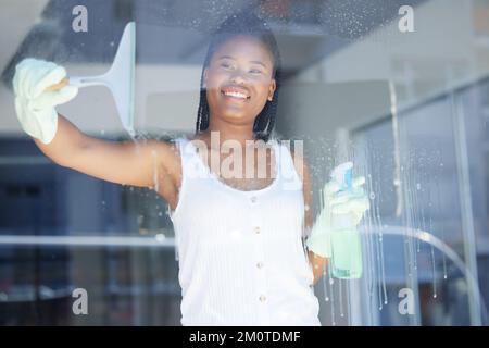 Femme noire, gants ou nettoyage de fenêtres à la maison, à la maison ou à l'hôtel dans l'entretien d'hygiène, le nettoyage de printemps de routine ou l'entretien ménager. Sourire, heureux ou Banque D'Images