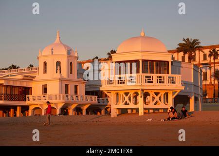 Espagne, Andalousie, Cadix, plage de la Caleta, jeunes sur le sable de la plage au pied de l'ancien centre thermal dans la lumière chaude de la fin de la journée Banque D'Images