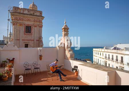 Espagne, Andalousie, Cadix, casa de las cuatro torres, guitariste flamenco jouant sur une chaise depuis la terrasse d'une tour commerçante du 18th siècle transformée en un hôtel de charme donnant sur la mer Banque D'Images