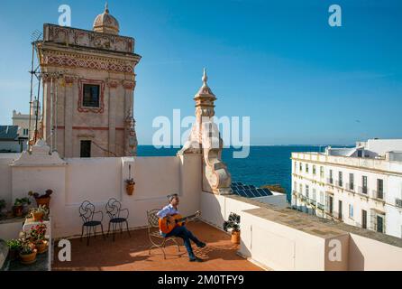 Espagne, Andalousie, Cadix, casa de las cuatro torres, guitariste flamenco jouant sur une chaise depuis la terrasse d'une tour commerçante du 18th siècle transformée en un hôtel de charme donnant sur la mer Banque D'Images