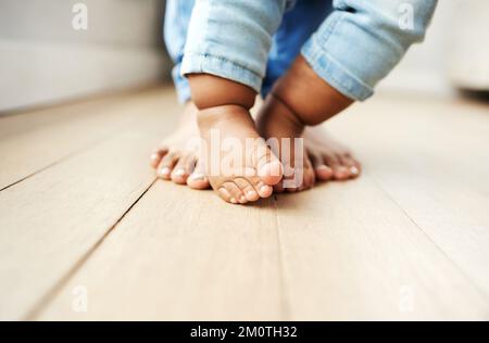 L'aider à faire ses premiers pas. une mère aidant son bébé à apprendre à marcher. Banque D'Images