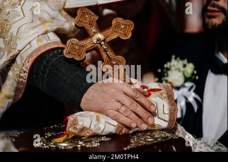 Ivano-Frankivsk, Ukraine, 2 octobre 2021 : la mariée et le marié se tiennent les mains de l'autre au cours d'une cérémonie de mariage d'église, le prêtre tient les mains de Banque D'Images