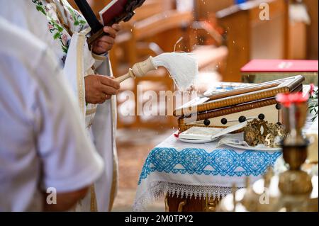 Ivano-Frankivsk, Ukraine : la mariée et le marié se tiennent les mains de l'autre lors d'une cérémonie de mariage d'église, trône dans l'église. Banque D'Images