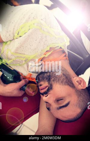 Faites la fête, buvez de l'alcool avec un homme qui dormait sur le sol après une fête du nouvel an ou un événement de clôture. Bière, sociale et fatiguée avec un homme endormi dans Banque D'Images