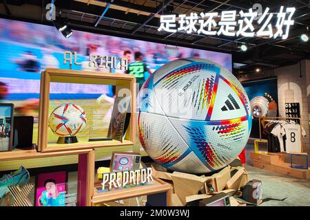 SHANGHAI, CHINE - 8 DÉCEMBRE 2022 - le ballon de match officiel DE la coupe du monde AL RIHLA et un modèle de football géant sont exposés dans un magasin Adidas à Shang Banque D'Images
