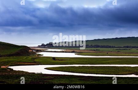 Les Coastguard Cottages au loin. Avec la rivière Cuckmere au premier plan. Parc national de South Downs. East Sussex, Royaume-Uni Banque D'Images