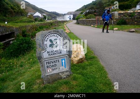 Homme marchant près du National Trust signe pour Boscastle Harbour près de la rivière Valency sur le South West Coastal Path à Cornwall, Angleterre, Royaume-Uni. Banque D'Images