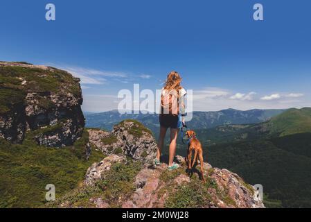 Femme Backpacker et Vizsla Dog sur Mountain Top Banque D'Images