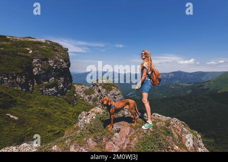 Femme Backpacker et Vizsla Dog sur Mountain Top Banque D'Images