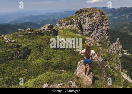 Femme randonneur debout seule sur Rock of Mountain Banque D'Images