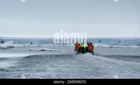 Touristes en bateau gonflable explorant le plateau de glace Larsen C, mer de Weddell, Antarctique. Banque D'Images