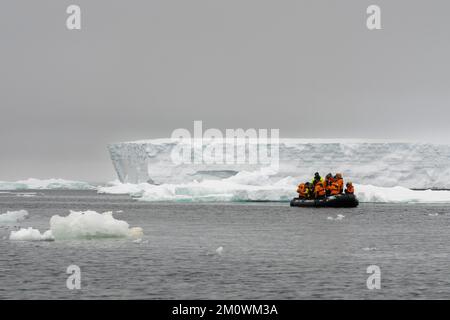 Touristes en bateau gonflable explorant le plateau de glace Larsen C, mer de Weddell, Antarctique. Banque D'Images