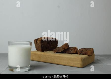 la vie est encore faite à partir du lait d'un gâteau sur une planche sur fond gris. petit déjeuner pain fruits lait. produits utiles Banque D'Images
