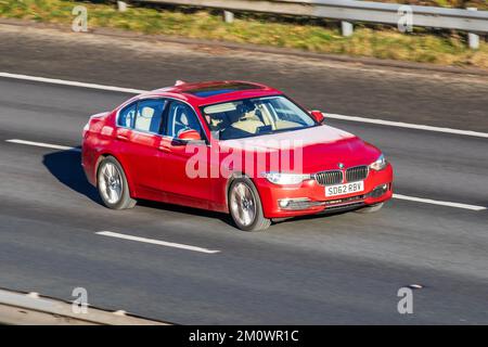 Glace sur voiture en mouvement   BMW 2012 rouge série 3 316D se 1995cc Diesel 6 vitesses manuelle; voitures givrées par temps froid. Temps d'hiver basses températures avec gel de décembre et conditions de conduite froides sur l'autoroute M61, Royaume-Uni Banque D'Images