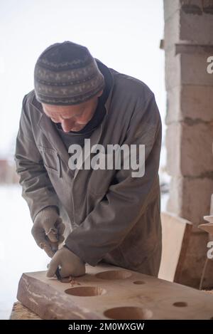 l'artisan sculpte les assiettes en bois à la main. L'art du menuisier Banque D'Images