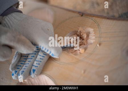 l'artisan sculpte les assiettes en bois à la main. L'art du menuisier Banque D'Images