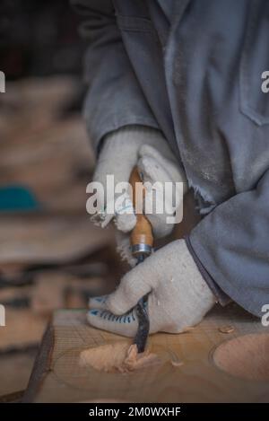 l'artisan sculpte les assiettes en bois à la main. L'art du menuisier Banque D'Images