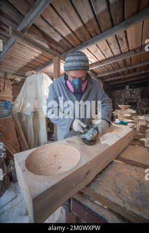 l'artisan sculpte les assiettes en bois à la main. L'art du menuisier Banque D'Images