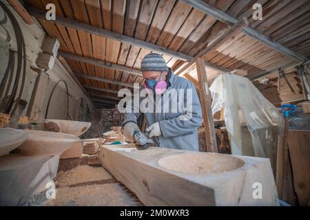 l'artisan sculpte les assiettes en bois à la main. L'art du menuisier Banque D'Images