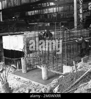 1950s, historique, aciéries en construction, ouvriers mettant des tiges d'acier à l'intérieur d'une structure, avant d'être concrétisé, Abbey Works, Port Talbot, pays de Galles du Sud, ROYAUME-UNI. L'acier renforcé, connu sous le nom d'armature, est utilisé dans les structures de maçonnerie pour renforcer et maintenir le béton en tension, car le béton ne résiste pas facilement aux contraintes et aux vibrations. Banque D'Images