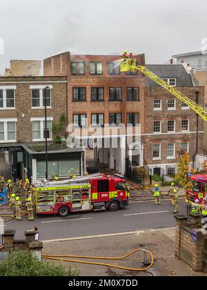 Brigade des pompiers assistez à un incendie dans un bâtiment résidentiel Banque D'Images