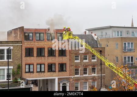 Brigade des pompiers assistez à un incendie dans un bâtiment résidentiel Banque D'Images