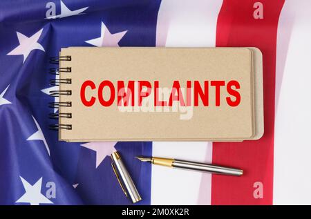 Concept de loi et d'ordre. Sur le fond du drapeau des Etats-Unis d'Amérique se trouve un carnet avec l'inscription - PLAINTES Banque D'Images