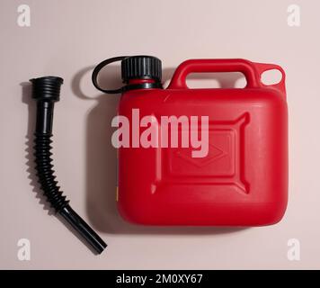 Cartouche en plastique rouge pour carburants liquides et lubrifiants sur fond beige, vue de dessus Banque D'Images