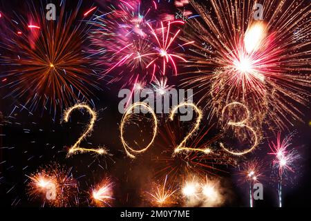 2023 bonne année écrit avec feu d'artifice Sparkle et des scintillers sur fond noir. Ciel nocturne à minuit la veille de Noël, illuminations d'anniversaire Banque D'Images