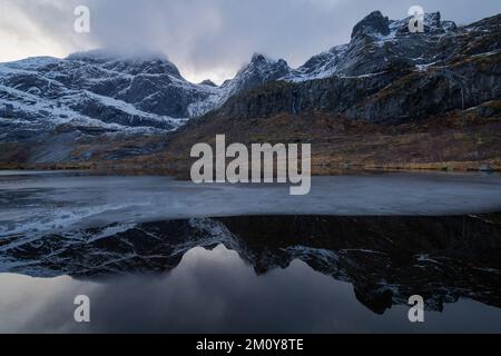 Réflexion de montagne dans un lac partiellement gelé, îles Lofoten, Norvège Banque D'Images