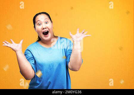 Femme asiatique de poids lourd avec une expression excitée et avec fond coloré Banque D'Images