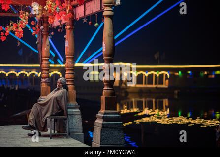 Srinagar, Inde. 08th décembre 2022. Un homme regarde comme il est assis près des maisons éliminées lors d'un festival pour stimuler le tourisme d'hiver à Srinagar. Crédit : SOPA Images Limited/Alamy Live News Banque D'Images