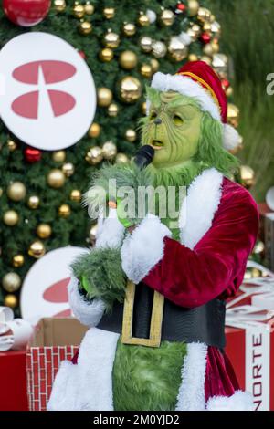 le grinch chantant et dansant derrière un arbre de noël avec de grands cadeaux, le mexique Banque D'Images