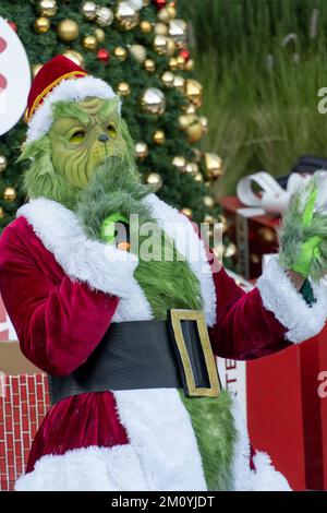 le grinch chantant et dansant derrière un arbre de noël avec de grands cadeaux, le mexique Banque D'Images