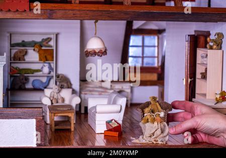 Altenhof, Allemagne. 08th décembre 2022. Katja Schülke pousse un fauteuil avec des petits ours dans le salon d'une maison qu'elle s'est construite dans son musée de la maison de poupées. La maison miniature a été modelée sur un original par un amateur entre 1993 et 1996. Il y a actuellement 60 modèles différents exposés dans la collection. La plupart des maisons datent des années 1950s et 1960s et ont été produites dans les monts Ore. Au total, la collection comprend plus de 140 maisons de poupées, l'une des plus anciennes datant de 1895. Credit: Jens Büttner/dpa/Alay Live News Banque D'Images