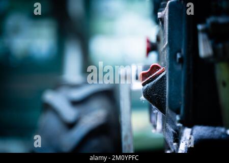 Orifice de remplissage pour le remplissage d'huile et jauge de niveau pour le contrôle du niveau d'huile. Goulot de remplissage sur le corps d'un tracteur à conducteur marchant gros plan sur un arrière-plan flou Banque D'Images