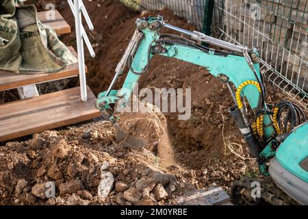 Une minipelle creuse une tranchée pour poser les tuyaux. Gros plan d'une pelle hydraulique creusant une tranchée profonde. Une pelle hydraulique creuse une tranchée dans la campagne pour déposer un Banque D'Images