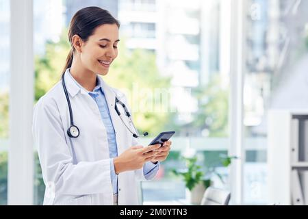 Cette application me permet de faire beaucoup plus. un jeune médecin utilisant un téléphone cellulaire dans un hôpital. Banque D'Images