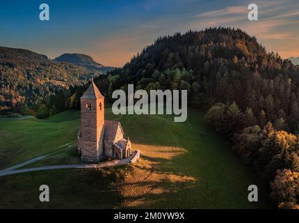 Hafling, Italie - vue aérienne de l'église de montagne de Saint Catherine (Chiesa di Santa Caterina) près de Hafling - Avelengo avec un chaud coucher de soleil d'automne à t Banque D'Images