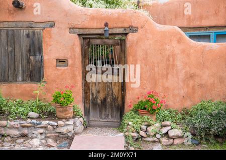 Porte en bois rustique dans l'ancien mur en adobe à Santa Fe, Nouveau-Mexique Banque D'Images