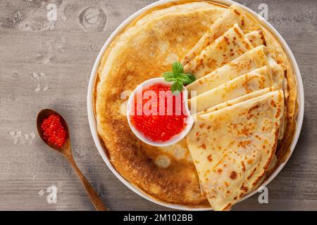 Crêpes avec caviar rouge sur une assiette. Le concept d'un festin festif Banque D'Images