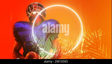 Joueur américain de football portant un casque et tenant le ballon debout par un cercle lumineux et des plantes. Orange, espace copie, composite, sport, compétition, Banque D'Images