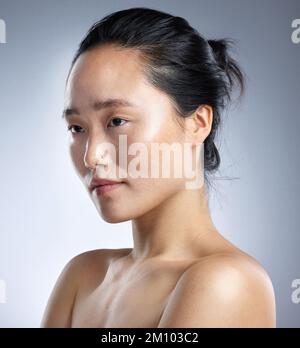 La peau n'a jamais été aussi belle. une jeune femme debout sur fond gris. Banque D'Images