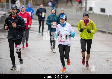 Les athlètes qui s'entraînent sous la pluie à l'occasion de la course de relais de marathon de Téléthon. Udine ville, Italie. 4 décembre 2022. Banque D'Images