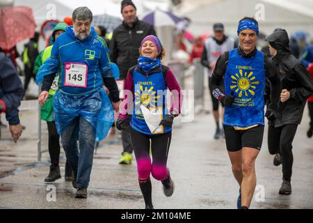 Les athlètes qui s'entraînent sous la pluie à l'occasion de la course de relais de marathon de Téléthon. Udine ville, Italie. 4 décembre 2022. Banque D'Images